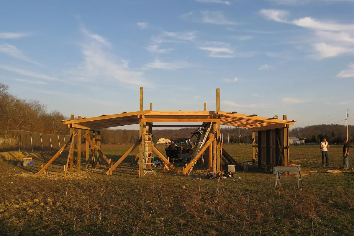Pole barn under construction with posts set in the ground