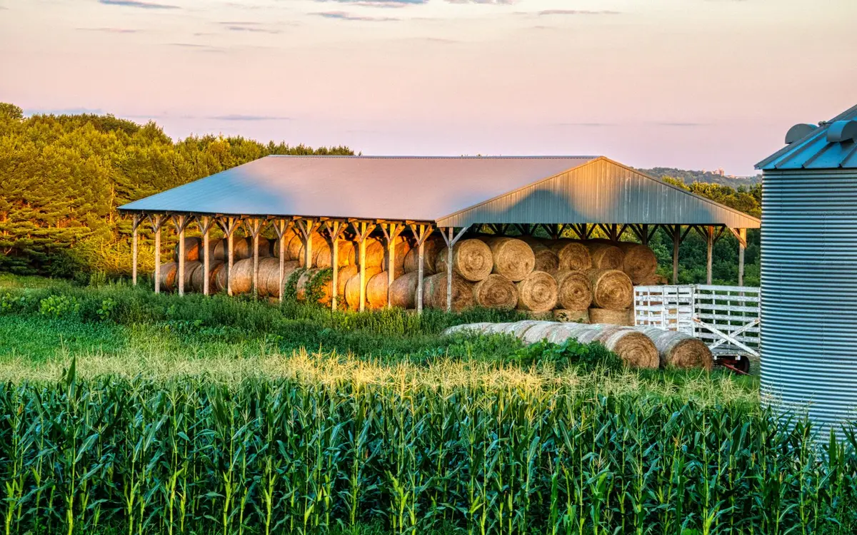 Open-sided pole barn storing round hay bales