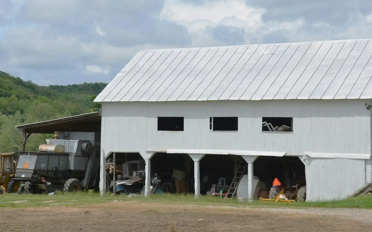 Barn with open machinery bays storing tractors and farm equipment