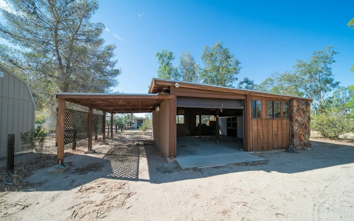 Detached wood-sided garage and workshop with an attached carport