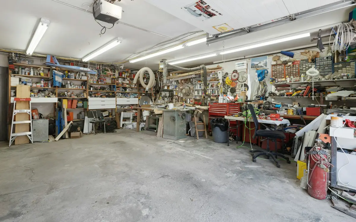 Inside a home garage workshop with workbenches and tool shelving